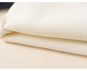 Close-up of soft white lamb wool fabric texture showing thickness and fluffy fiber detail