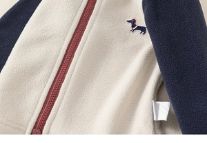 Λεπτομέρεια παιδικής ζακέτας fleece με κέντημα σκύλου λουκάνικο και μπορντό φερμουάρ