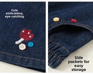 Détail de broderie de fleurs rouges et boutons colorés sur poches de jupe en jean