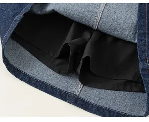 Détail d'une jupe en jean bleu foncé avec une doublure de sécurité noire et des coutures