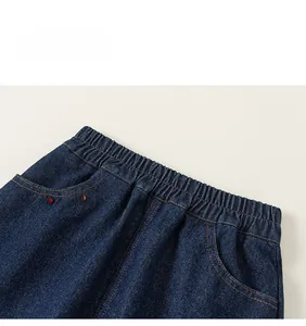 Détail de la taille élastique et des surpiqûres contrastées jaunes sur la jupe en jean
