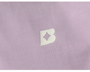 Macro detail of lavender ripstop fabric texture with white B letter logo on jacket