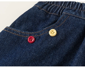 Détail macro de jupe en jean enfant avec taille élastique et coutures contrastées orange