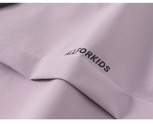 Detail view of purple ripstop fabric with black ALLFORKIDS logo and precise stitching