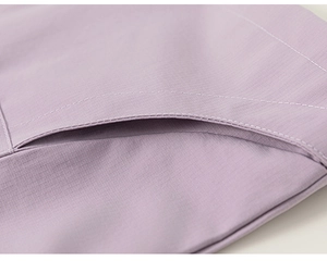 Detail of light purple girls outdoor jacket showing ripstop fabric texture and pocket stitching