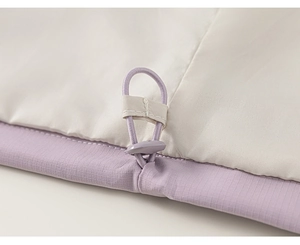 Detailed macro view of purple ripstop jacket hem with adjustable elastic drawcord and toggle