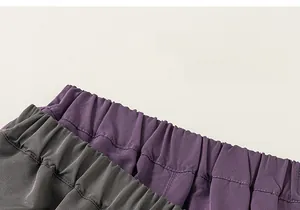 Detail showing elastic waistbands of soft textured dark grey and purple casual trousers