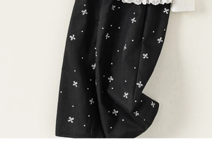 Détail du haut en coton pour filles avec pois blancs, nœuds et bordure en dentelle