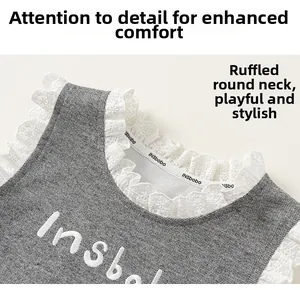 Détail du col rond à volants et de l'étiquette de marque sur un haut de gilet gris texturé