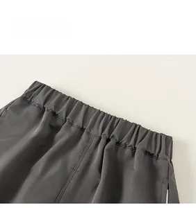 Detailed view of elastic waistband on dark grey cargo pants with flat seams and high stretch