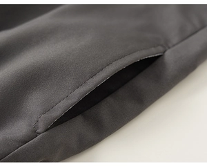Close-up of the durable stitching and texture on the dark grey cargo pants side pocket