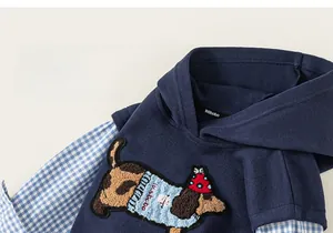 Detail of children's faux two-piece hoodie featuring dog embroidery and navy knit texture