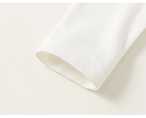 Gros plan du poignet en maille blanche avec des coutures à double aiguille soignées