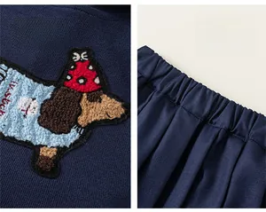 Detail of navy blue knit fabric with puppy cartoon embroidery and elastic pleated waistband