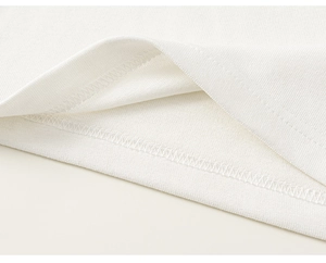 Détail de l'ourlet en tricot fin avec double couture soignée en blanc cassé
