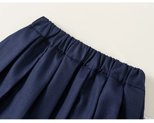 Close-up of pleated navy blue skirt showing elastic waistband and fine fabric texture