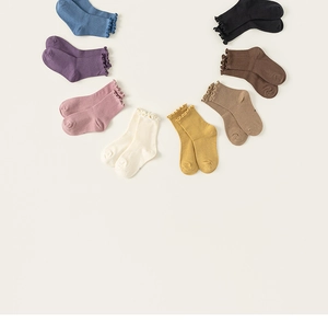 Detail view of eight colorful seamless cotton socks with stylish ruffled cuffs for kids