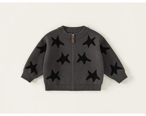Detail of baby knit cardigan with dark grey star pattern and leather zip puller
