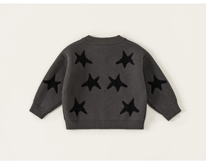 Detail of dark grey knit sweater for boys featuring a black star pattern and ribbed cuffs