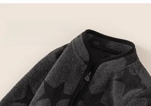 Close-up of boys' grey fleece zip-up jacket featuring black star patterns and stand collar