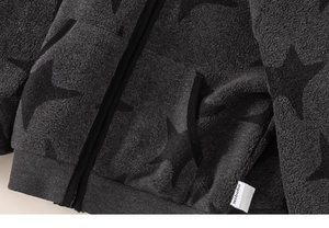 Detailed close-up of thick grey fleece fabric texture and black star pattern on kid's jacket