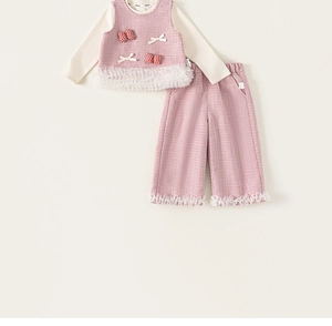 Detail of toddler 3-piece tweed set featuring pink vest with bow and white lace tassels