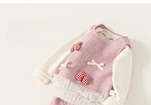 Close-up of pink tweed vest dress with white mesh hem and long sleeve shirt set