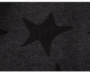 Close-up of dark grey knit fabric with black star pattern on a boys cardigan sweater