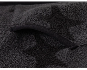 Detail of dark grey star pattern fleece fabric with black piping on the pocket opening