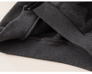 Macro shot of dark grey fleece sweater fabric with elastic ribbed cuffs and fine texture