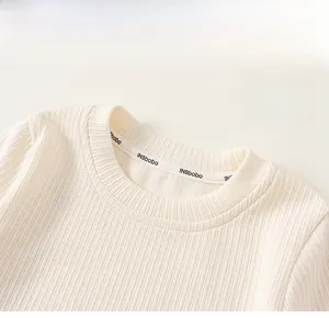 Close-up of cream ribbed knit sweater neckline with delicate fabric texture details
