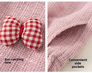 Detail of pink tweed vest showing red plaid bow decoration and side pocket functional design