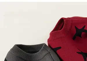 Close-up of star jacquard knit sweater collars in deep grey and burgundy colors