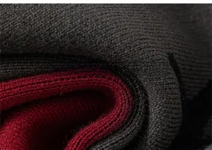 Close-up of deep red and charcoal grey knitted wool fabric texture with thick yarn patterns