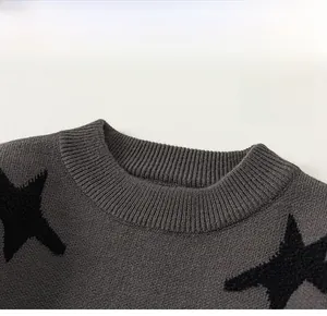 Detailed view of grey knit sweater for boys with black star pattern and classic crew neck