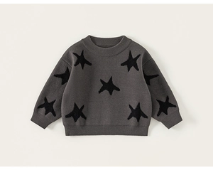 Detail of grey knitted sweater for boys featuring black star patterns and fine stitching