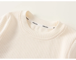 Detailed macro view of the cream ribbed knit neckline with high quality stitching