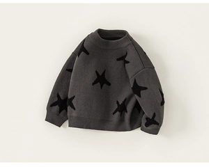 Close-up of baby boy knit sweater featuring dark grey fabric and black star patterns