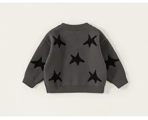 Detailed view of dark grey knitted cardigan featuring black star jacquard and ribbed edges