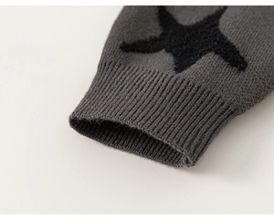 Detailed view of dark grey knitted cardigan sleeve with black star pattern and ribbed cuffs