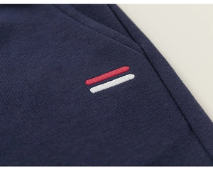 Vue macro de la poche en tricot bleu marine avec détails de broderie rouge et blanc