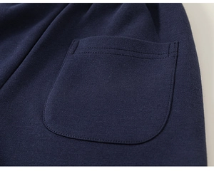 Détail de la poche cousue double et texture en coton tricoté sur le jogging bleu marine