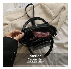 Detailed view of internal capacity in black quilted bag with pink metal coin purse
