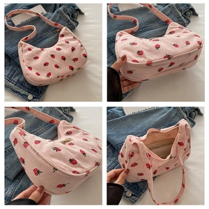 Detailed view of pink corduroy hobo bag with red strawberry embroidery and zip closure