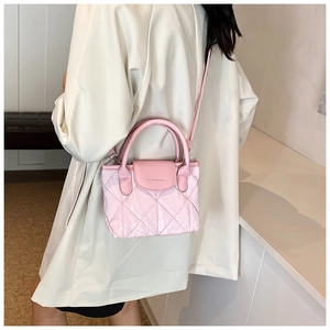 Close-up of pink quilted crossbody bag with top handle and Fashion & Bags lettering
