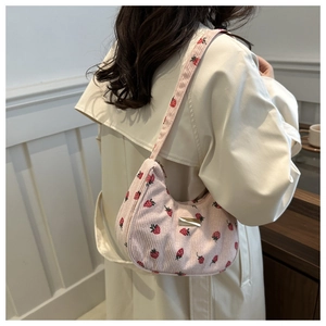 Detail of pink corduroy crescent bag with red strawberry print and golden buckle
