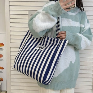 Blue and white striped canvas tote bag with Leo patch shown on a model for daily style