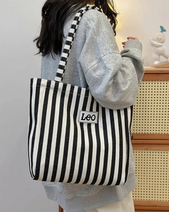 Detail of blue and white striped canvas tote bag with Leo logo and shoulder strap