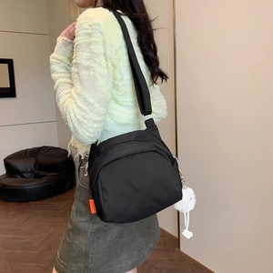 Retro black canvas crossbody bag with orange fashion tag and soft white pompom detail