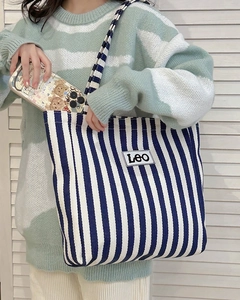 Detail of blue and white striped canvas tote bag showing spacious interior and LEO patch